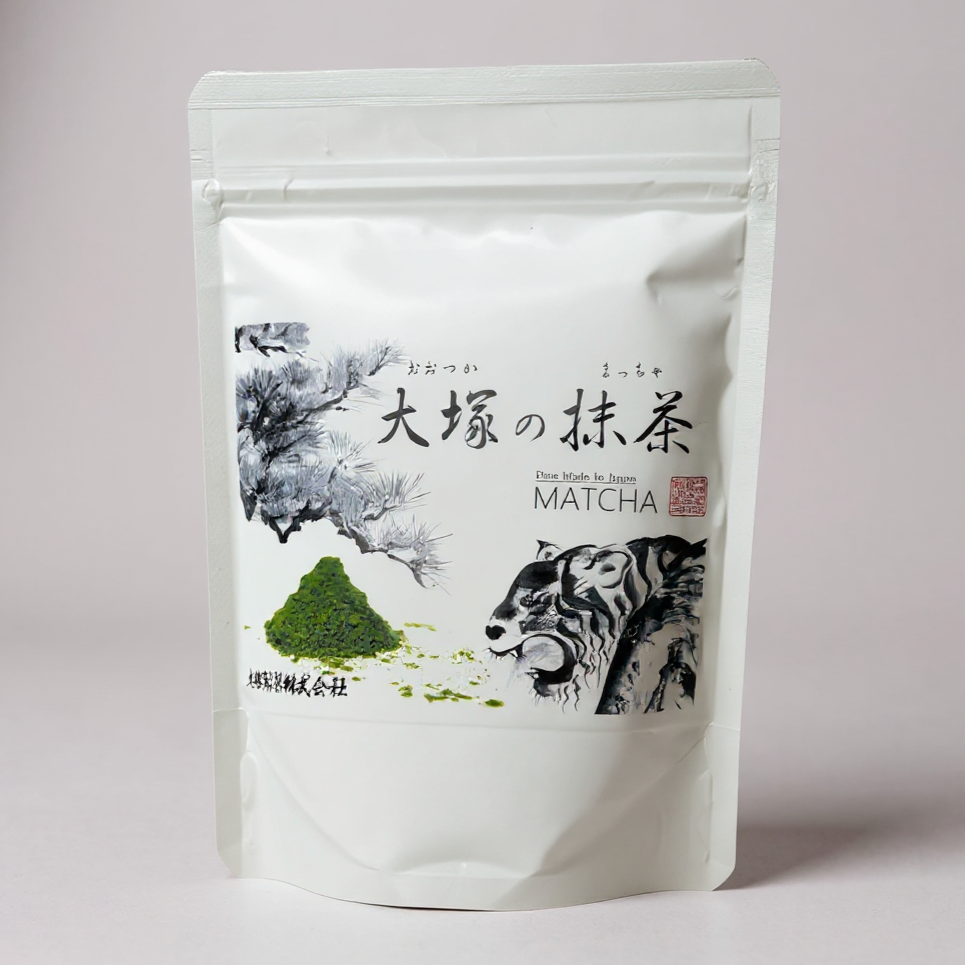 White packaging of Otsuka Matcha with Japanese text and illustrations on a light gray background