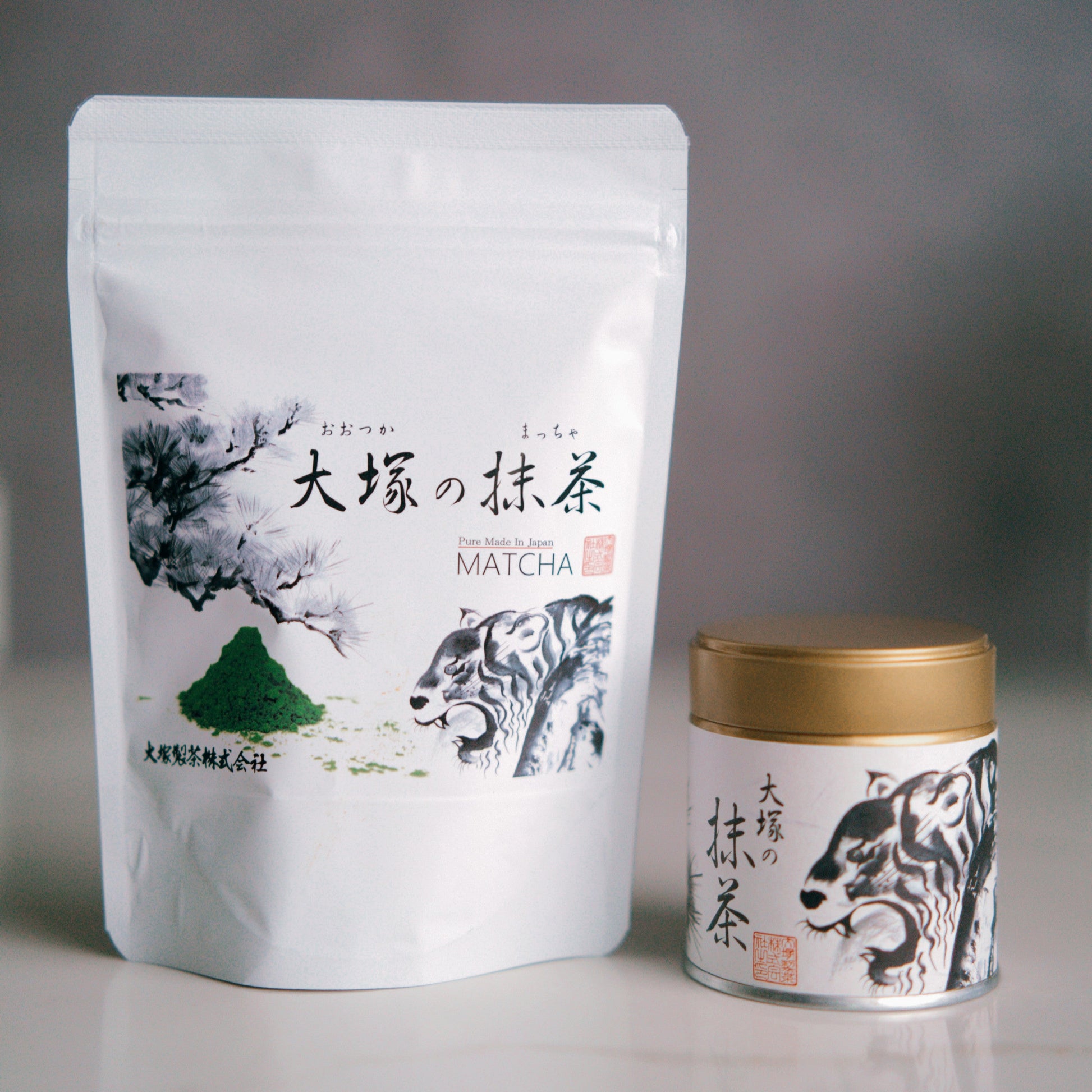 White packaging of matcha tea with a gold lid on a gray background