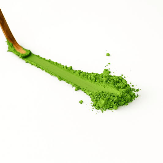 Ceremonial matcha Japan powder spread on a white surface with a bamboo whisk